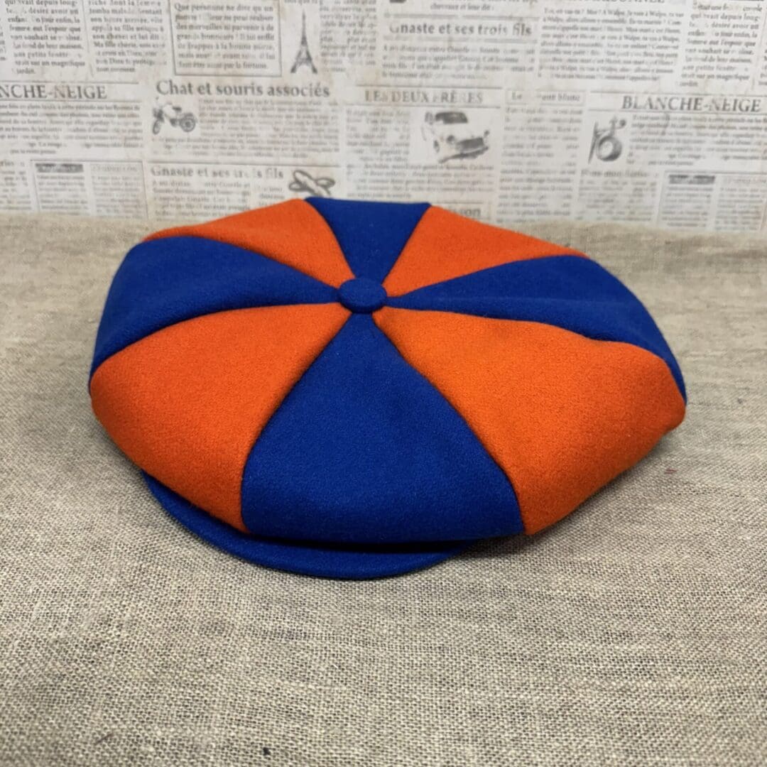 Blue and orange eight-panel newsboy cap.