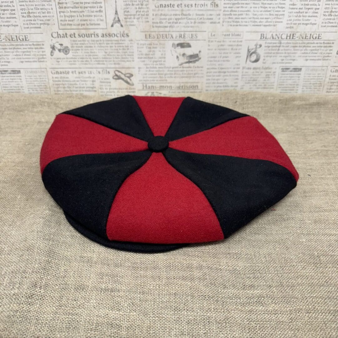 Red and black eight-panel newsboy cap.