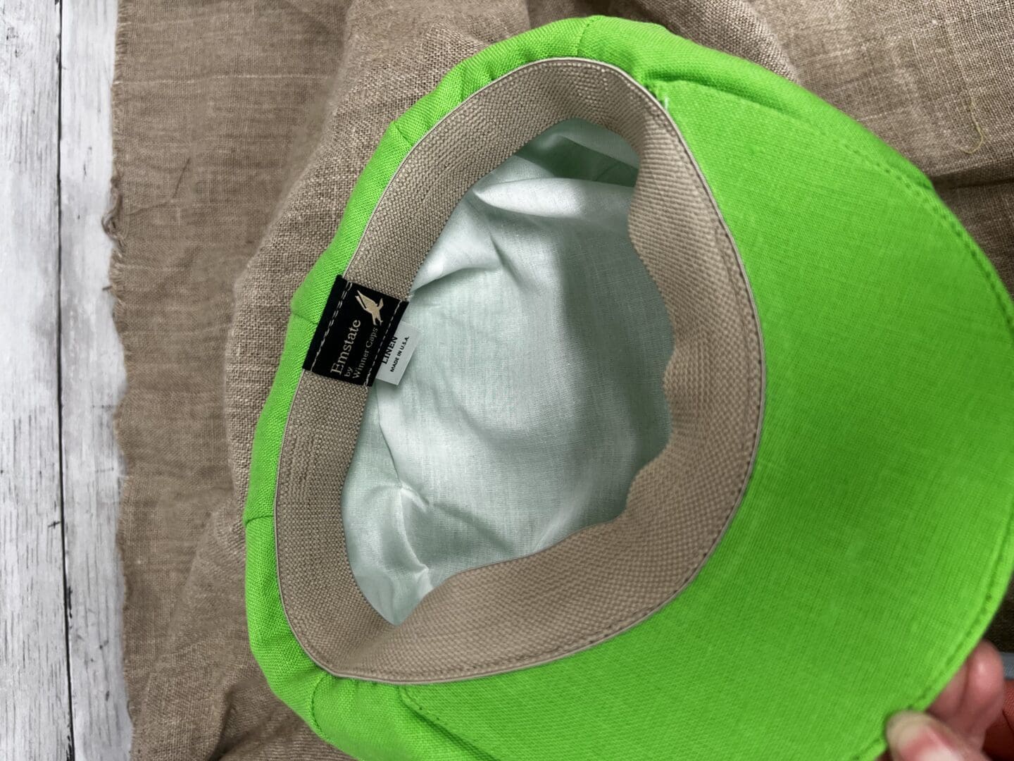 A green hat with silver lining on top of it.