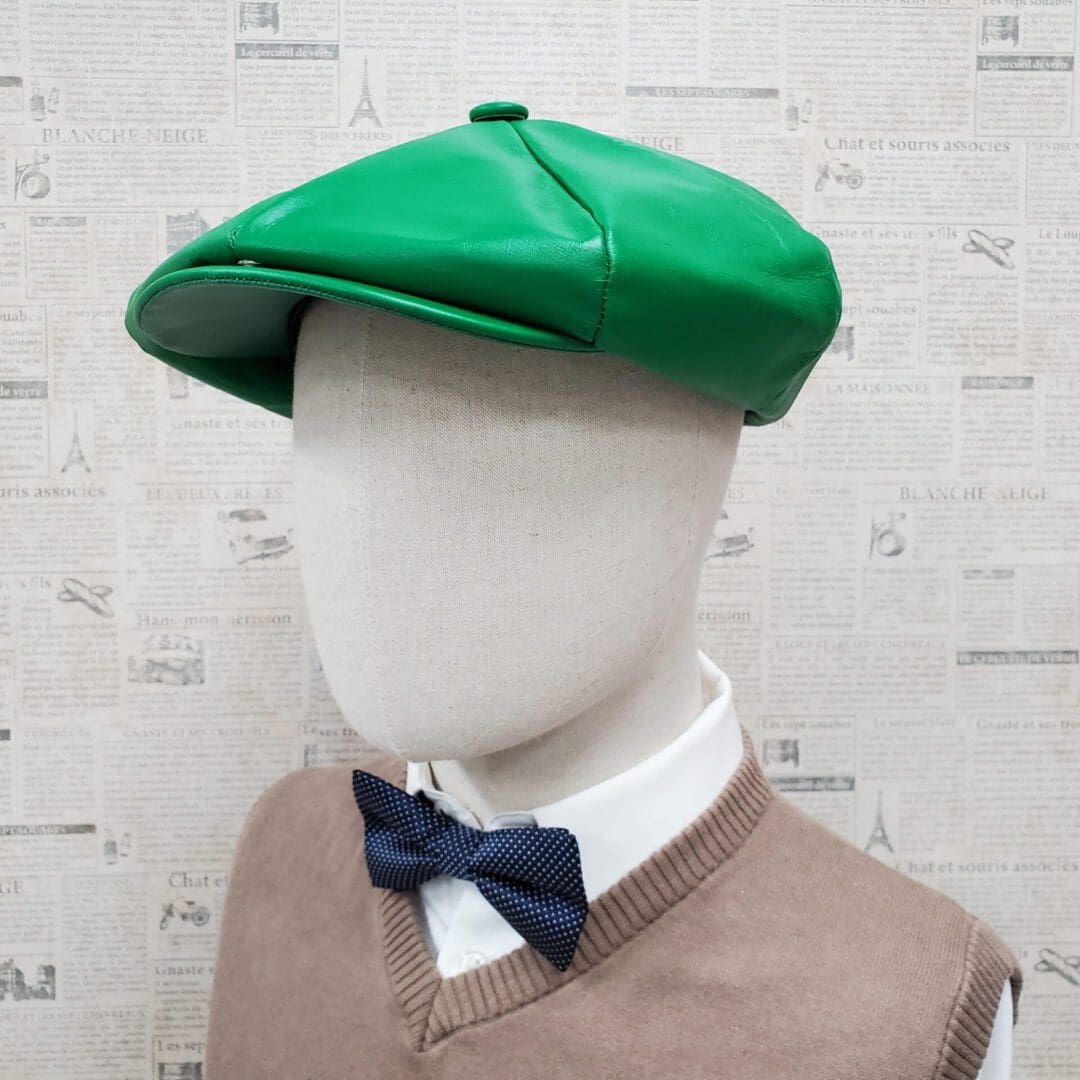 A mannequin wearing a green hat and bow tie.