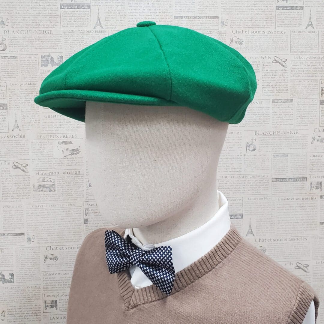 A mannequin wearing a green hat and bow tie.