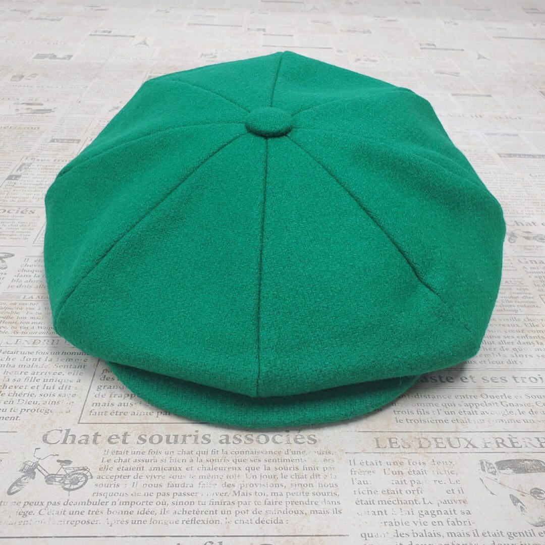 A green hat sitting on top of a newspaper.