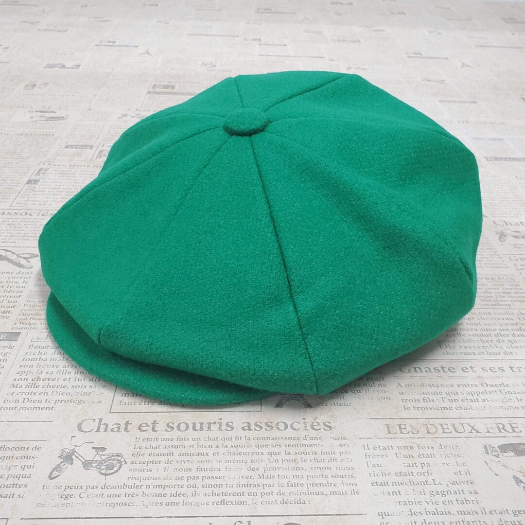 A green hat sitting on top of a newspaper.