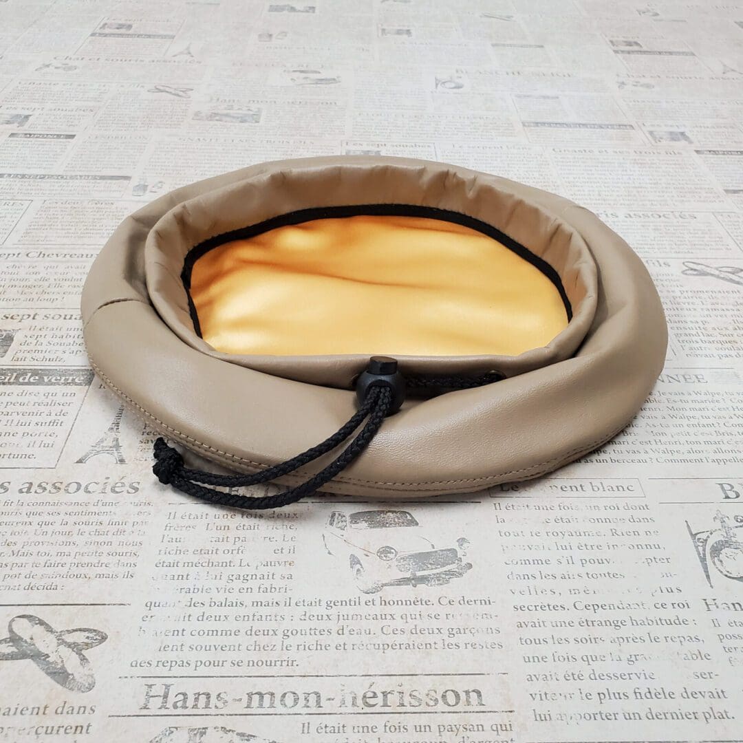 A round bag with a yellow pillow inside of it