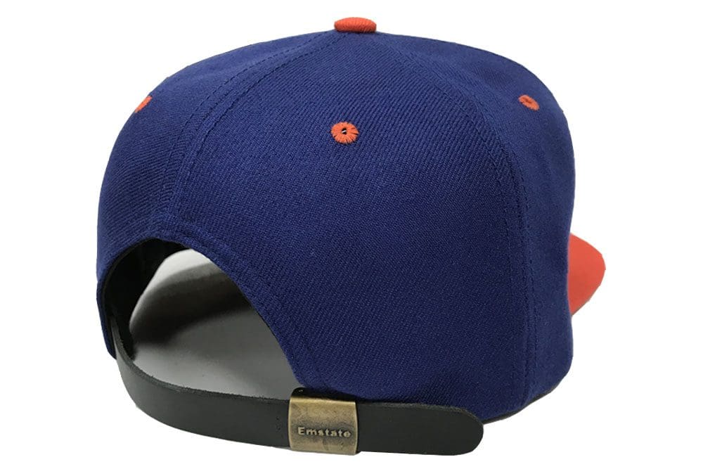 A blue and orange hat is on the side of a white wall.