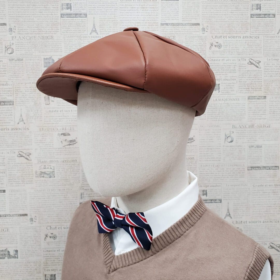 A mannequin wearing a brown hat and bow tie.