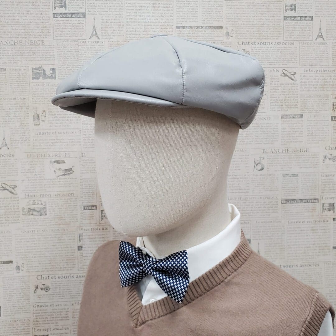 A mannequin wearing a bow tie and hat.