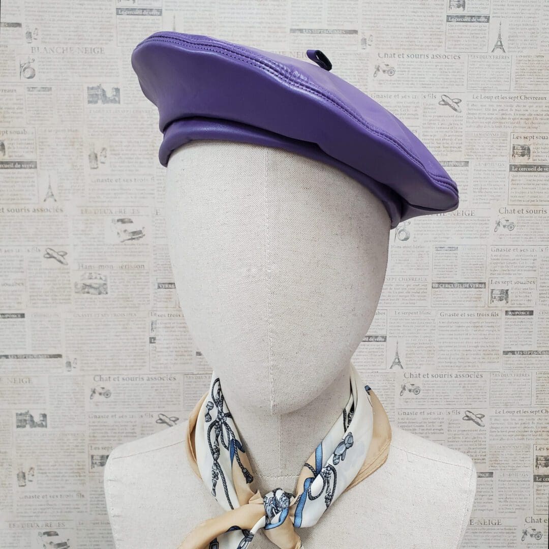 A mannequin wearing a purple hat and chain necklace.