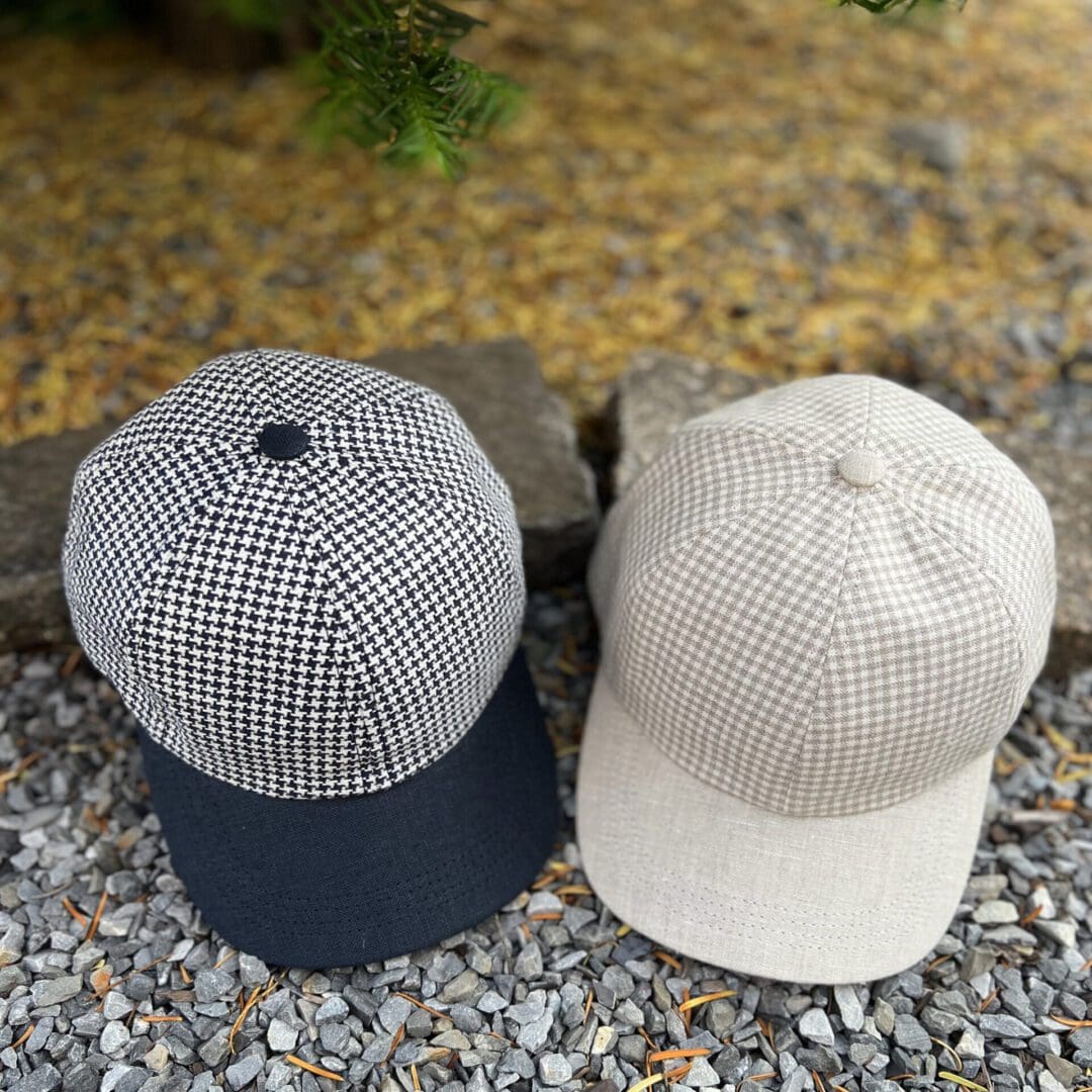 Two hats are sitting on the ground outside.