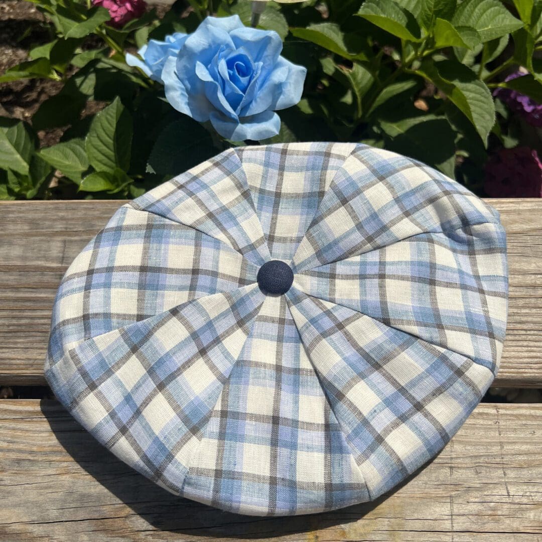 A blue and white plaid hat sitting on top of a wooden table.