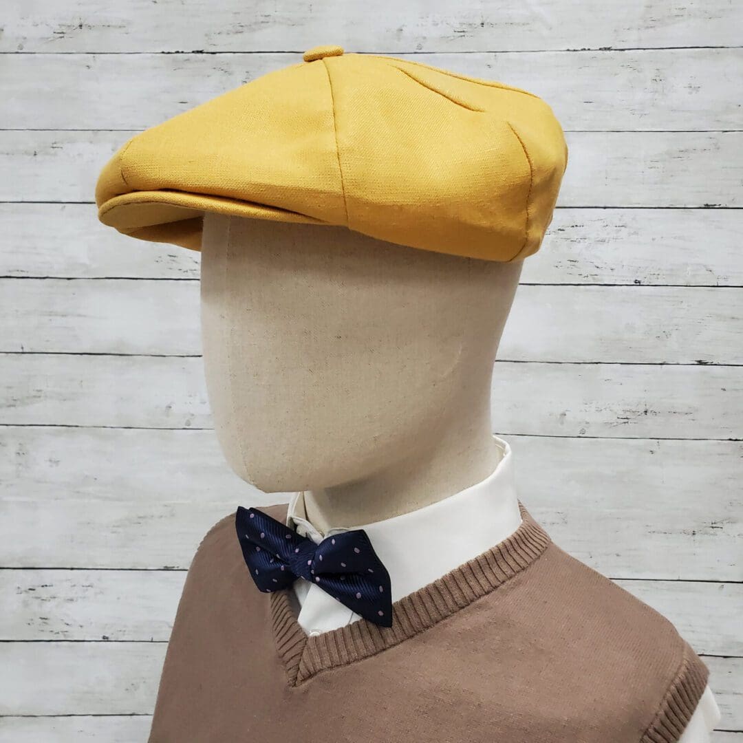 A mannequin wearing a yellow hat and bow tie.