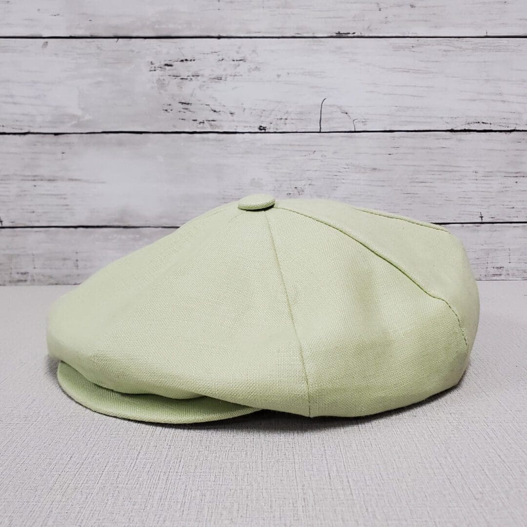 A light green hat is sitting on top of a table.