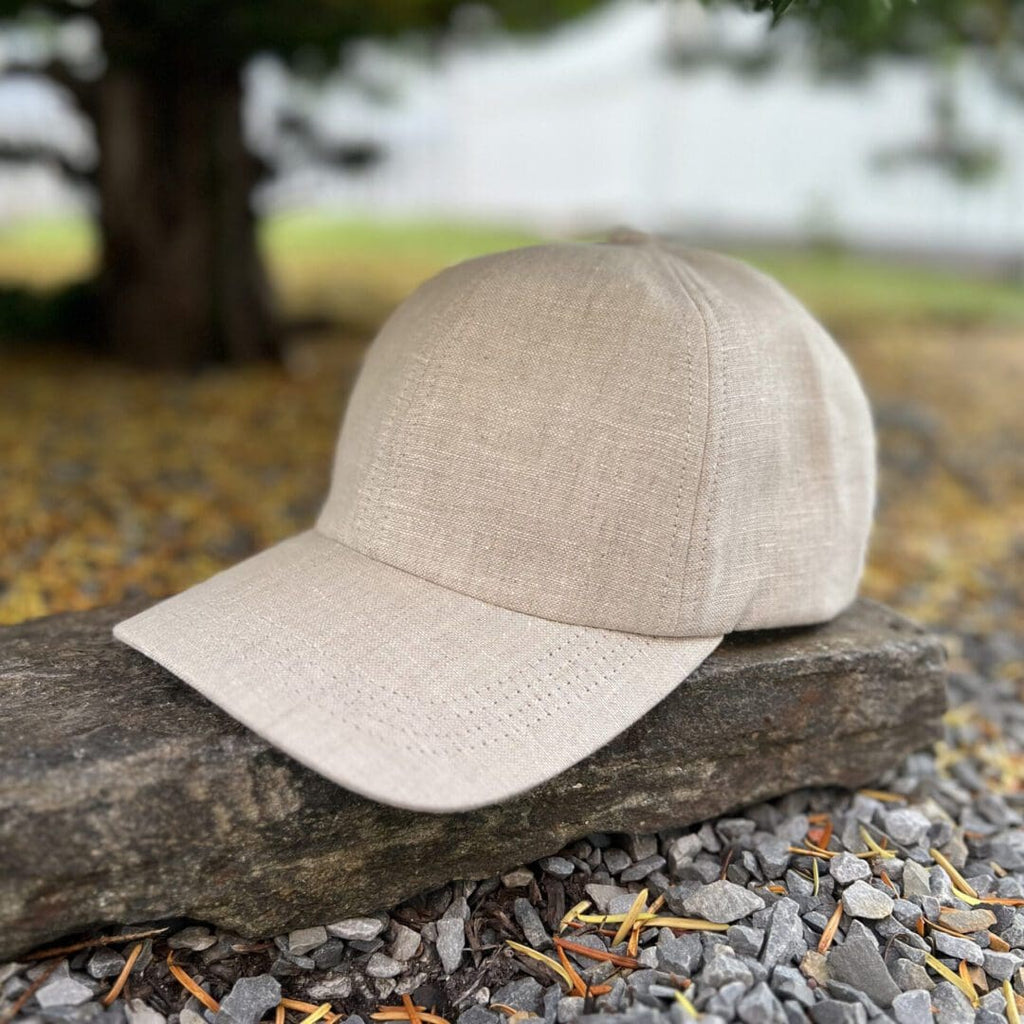 A hat is sitting on the ground near some leaves.