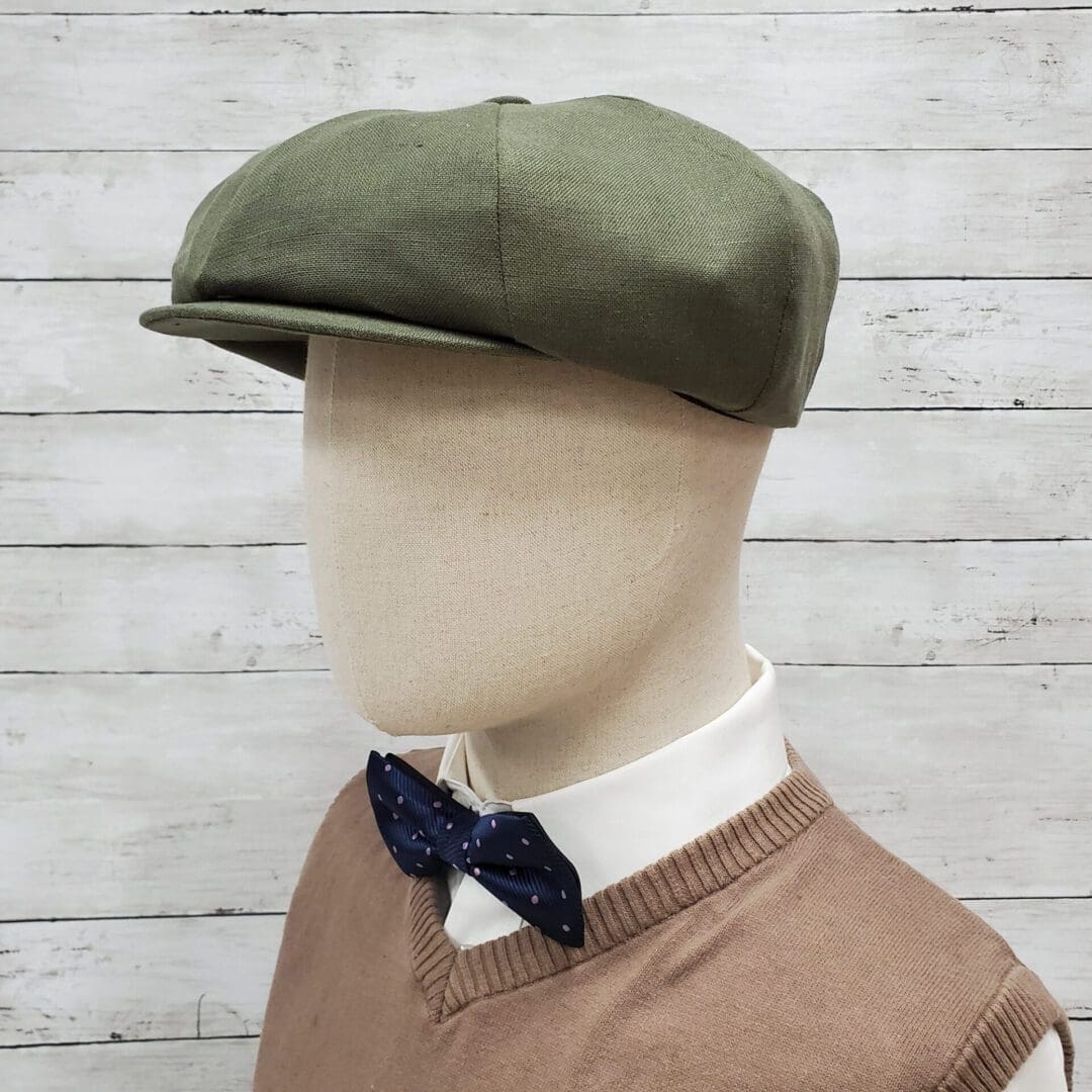 A mannequin wearing a green hat and bow tie.