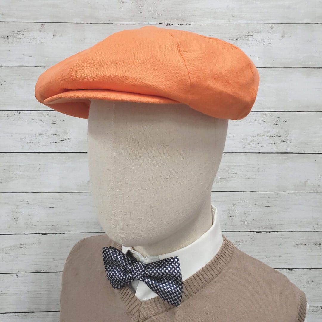 A man wearing an orange hat and bow tie.