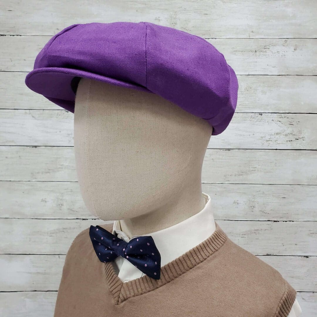 A mannequin wearing a purple hat and bow tie.