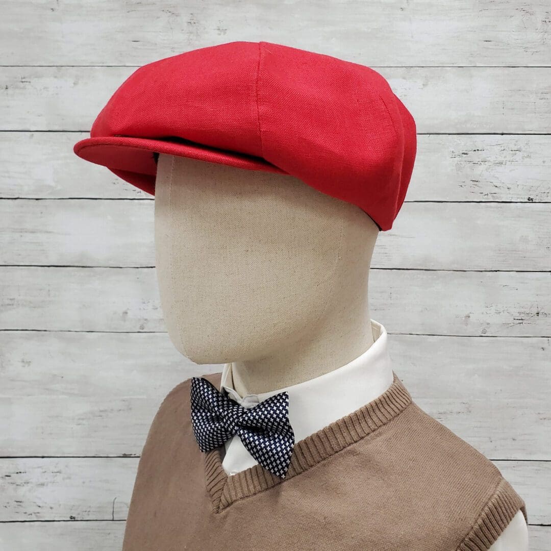 A mannequin wearing a red hat and bow tie.