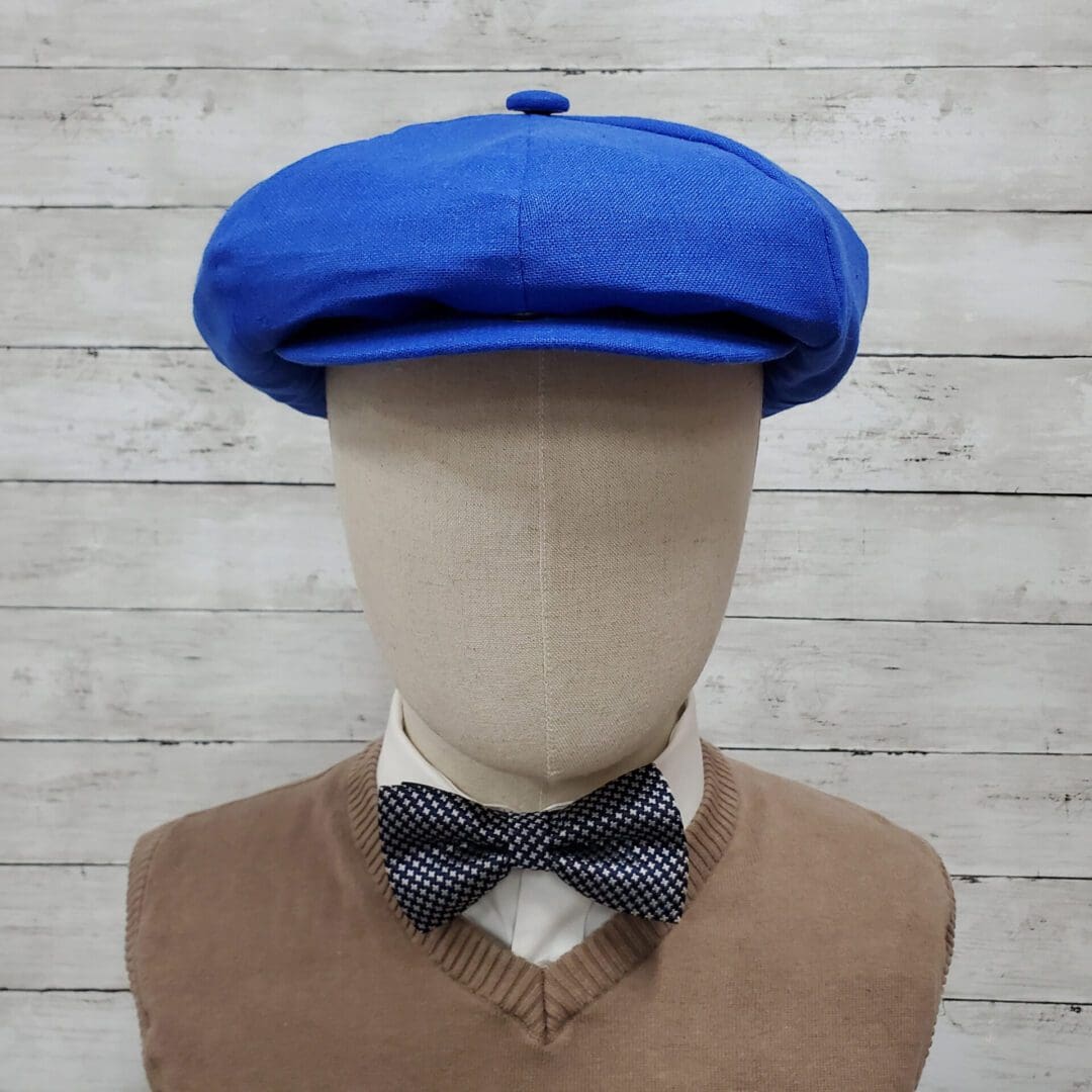 A mannequin wearing a blue hat and bow tie.