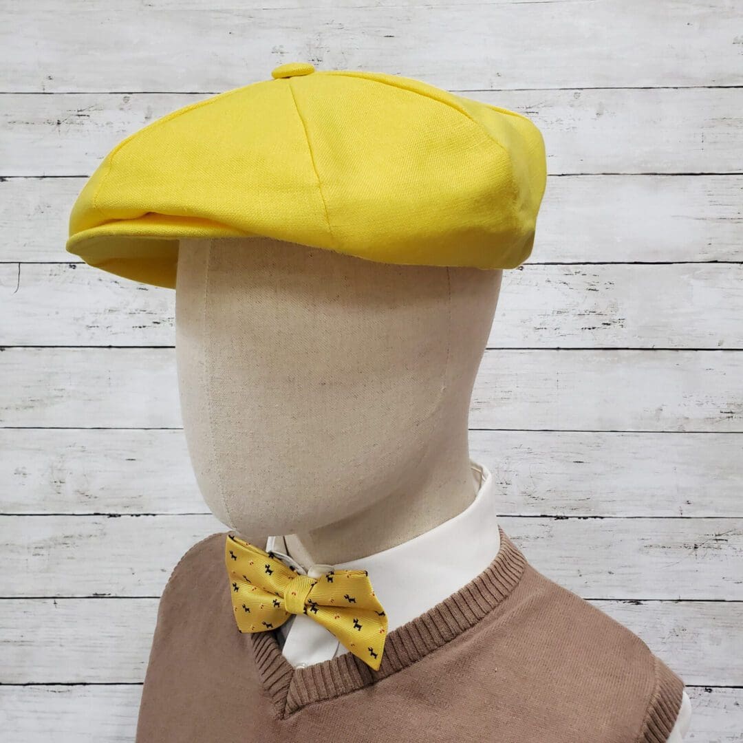 A mannequin wearing a yellow hat and bow tie.