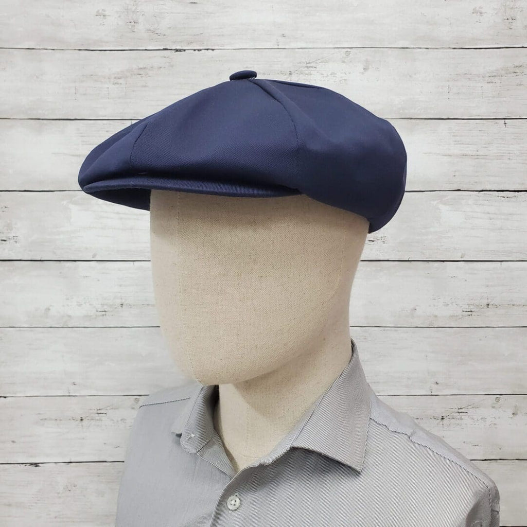 A man wearing a blue hat and gray shirt.