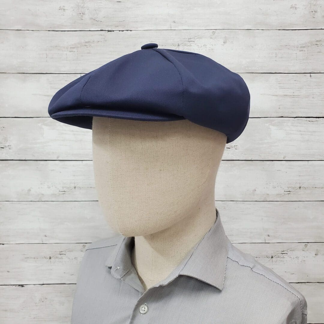 A man wearing a blue hat and gray shirt.