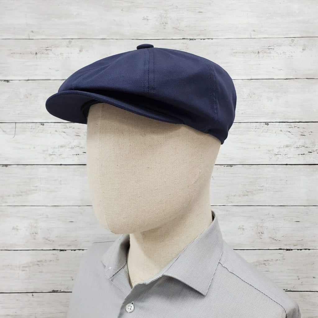 A man wearing a hat with a gray shirt.