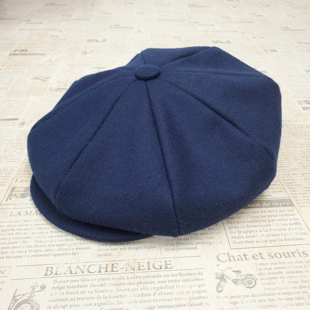A blue hat sitting on top of a newspaper.