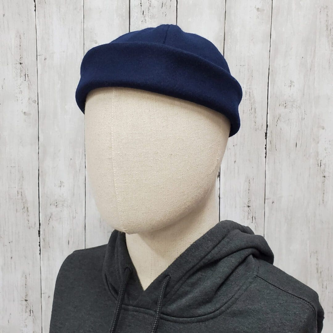 A mannequin wearing a blue hat and black hoodie.