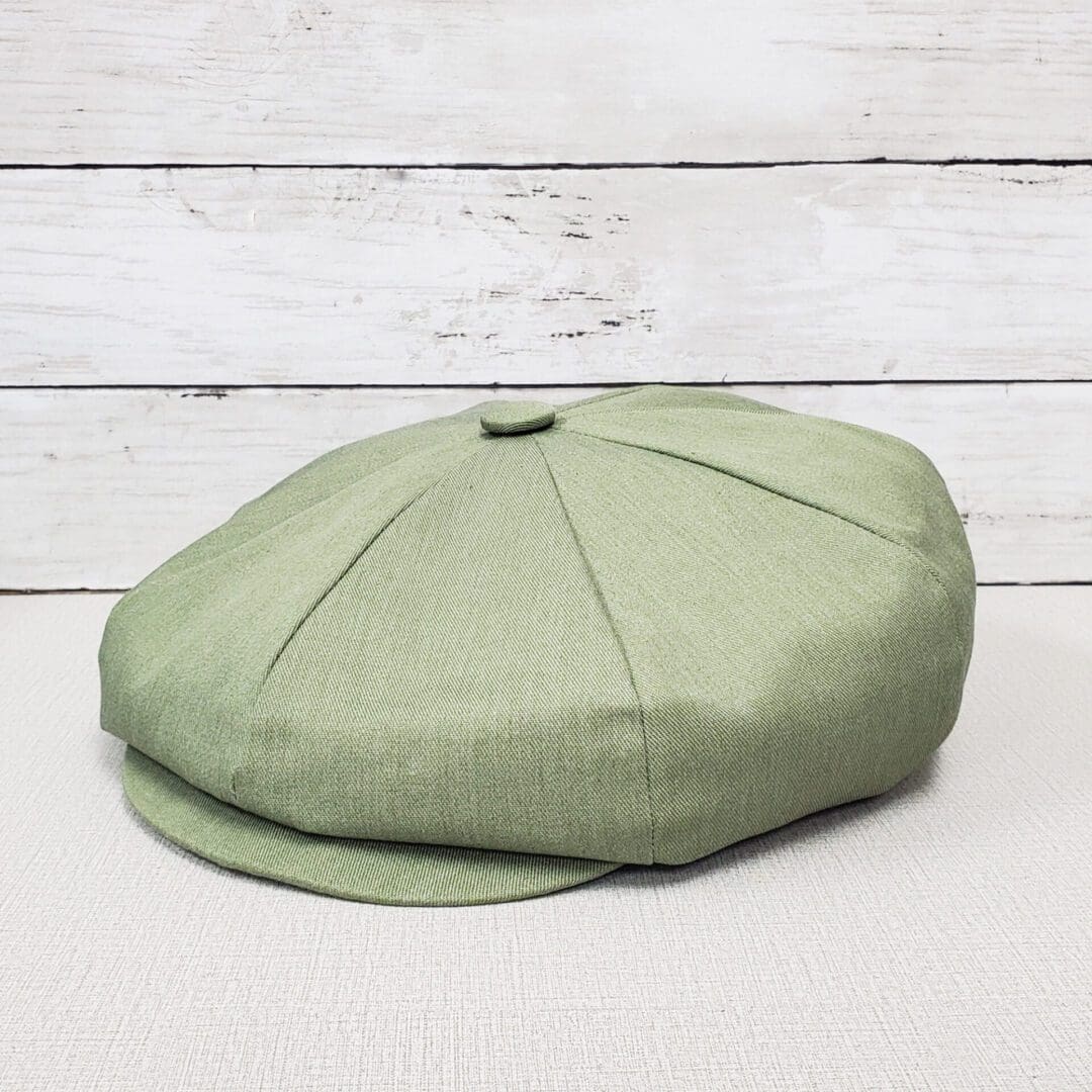A green hat sitting on top of a wooden table.
