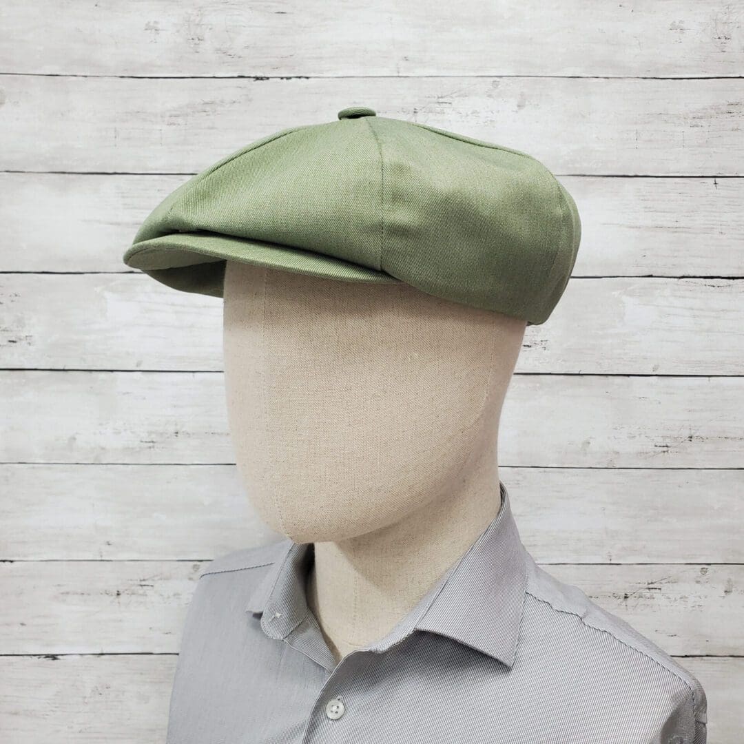 A man wearing a green hat and gray shirt.