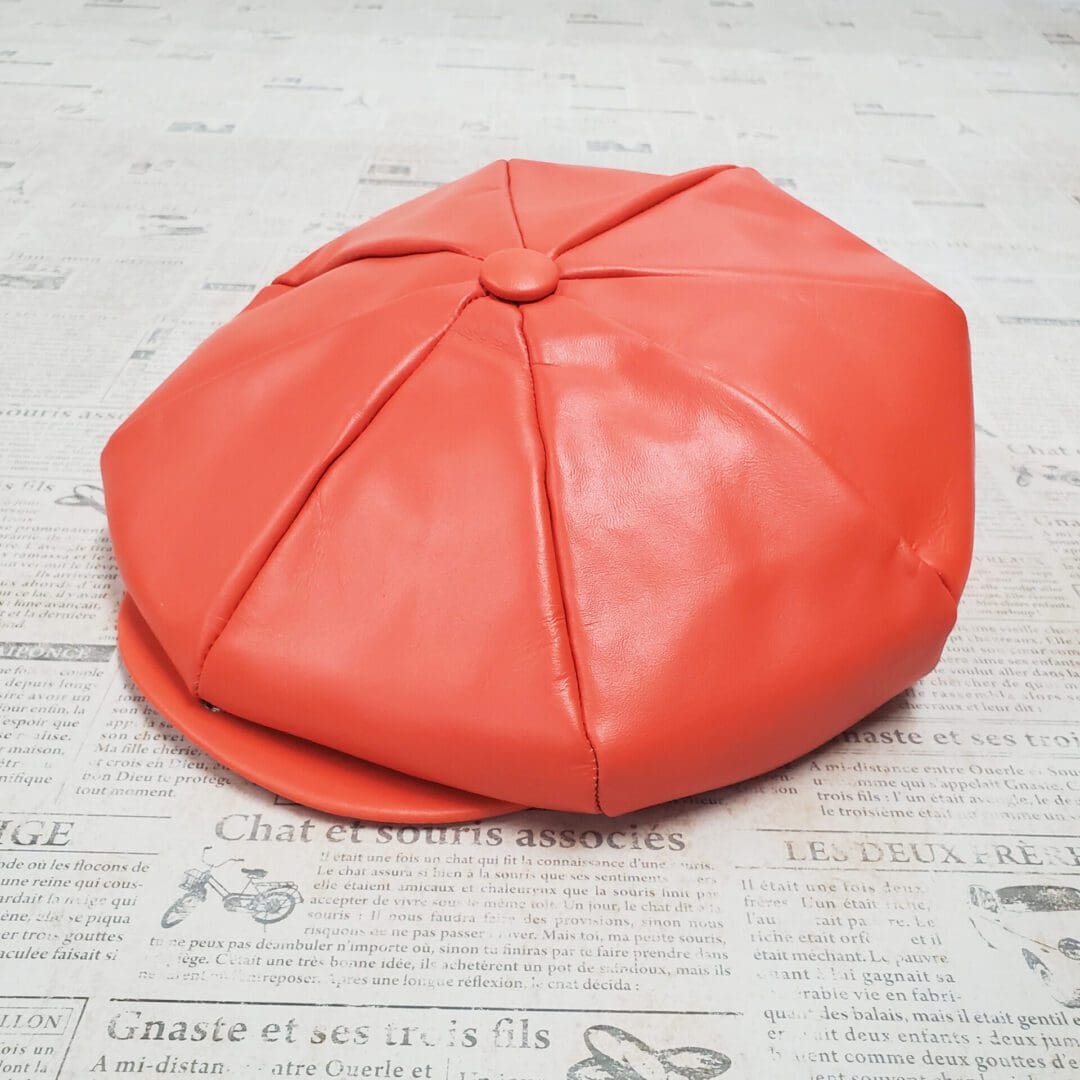 A red hat sitting on top of a newspaper.