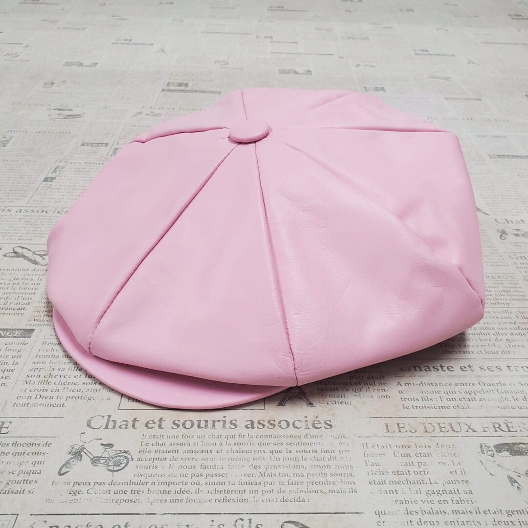 A pink hat sitting on top of a table.