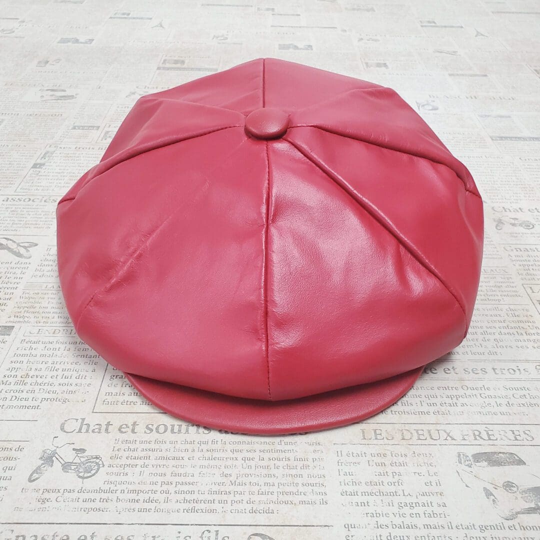 A red hat sitting on top of a newspaper.