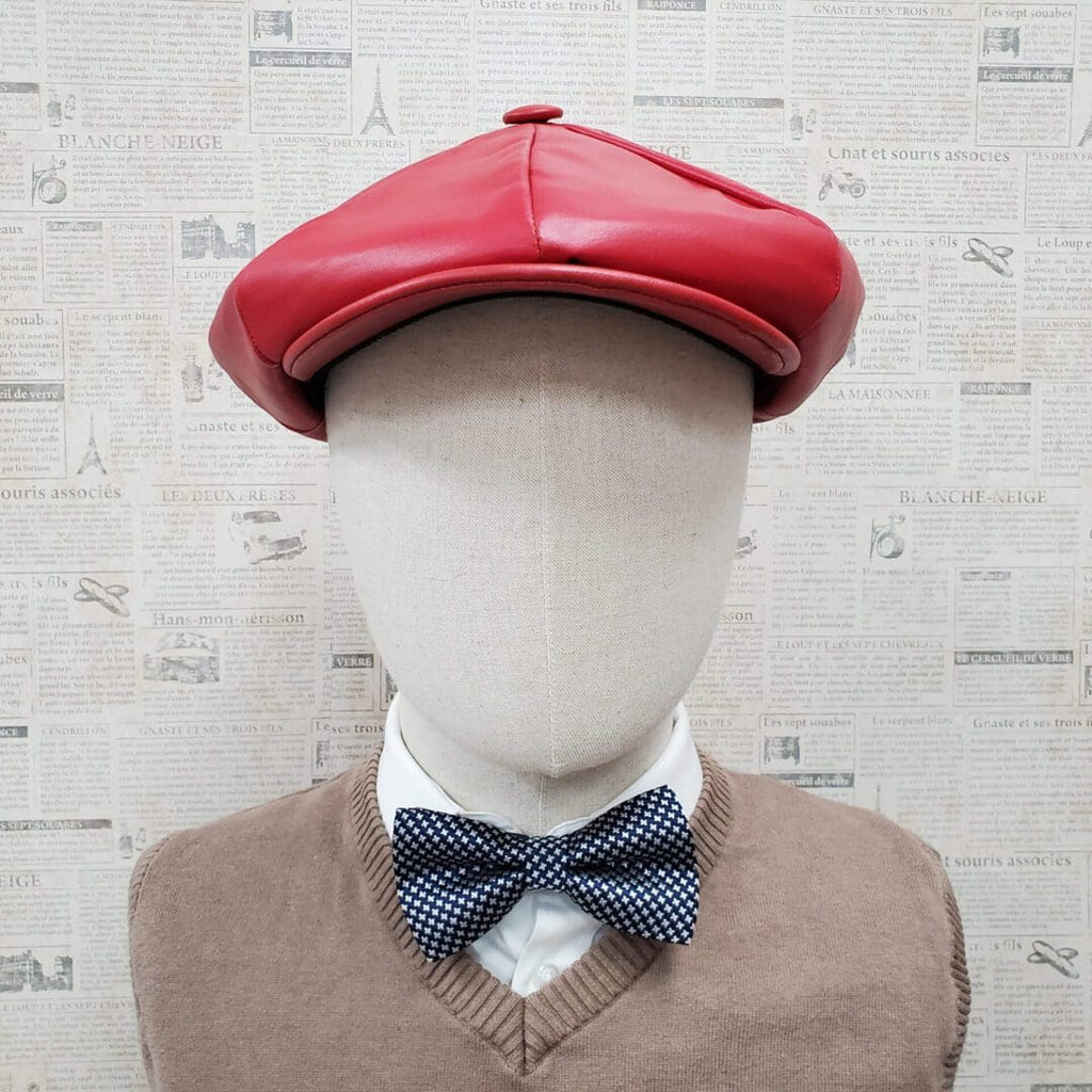 A mannequin wearing a red hat and bow tie.