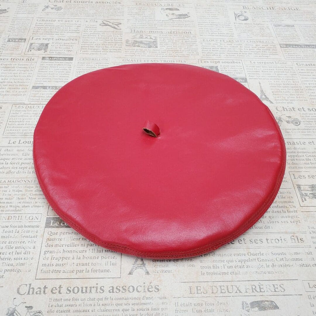 A red frisbee sitting on top of newspaper.