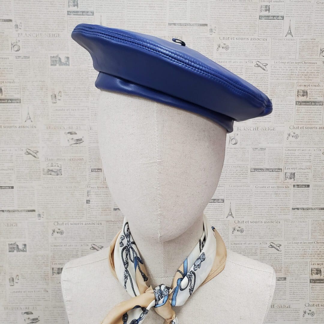 A mannequin wearing a blue hat and neck tie.