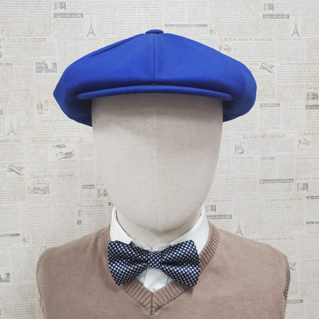 A mannequin wearing a bow tie and a blue hat.