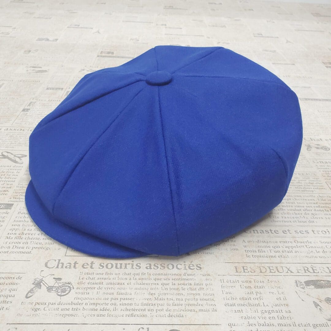 A blue hat sitting on top of newspaper.