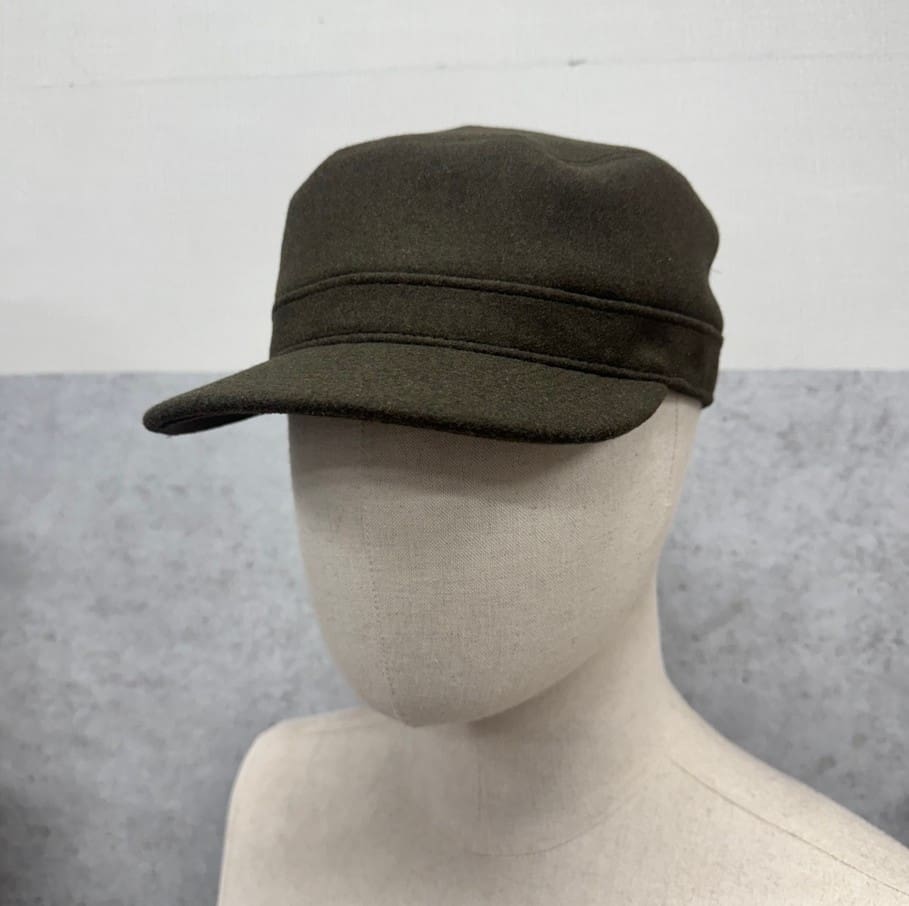 Mannequin wearing dark green military cap.