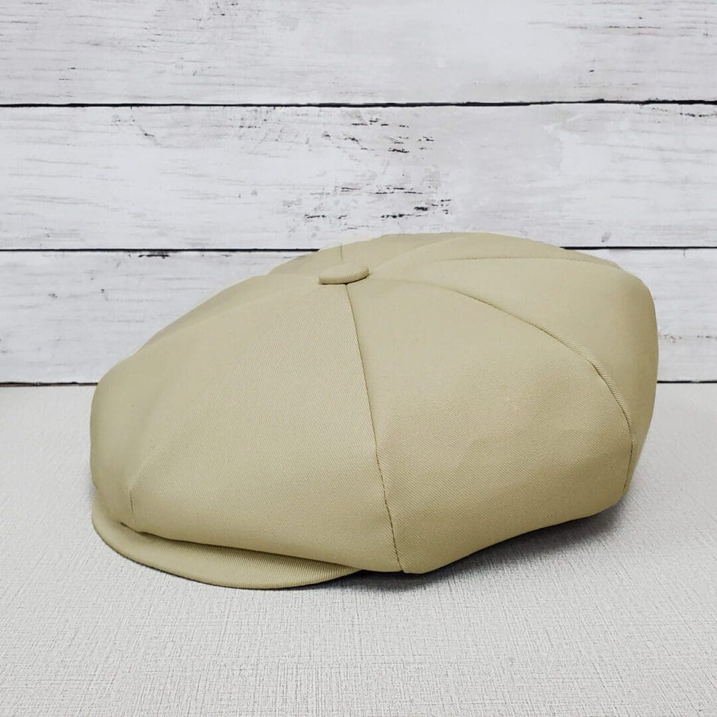 A tan hat sitting on top of a wooden table.