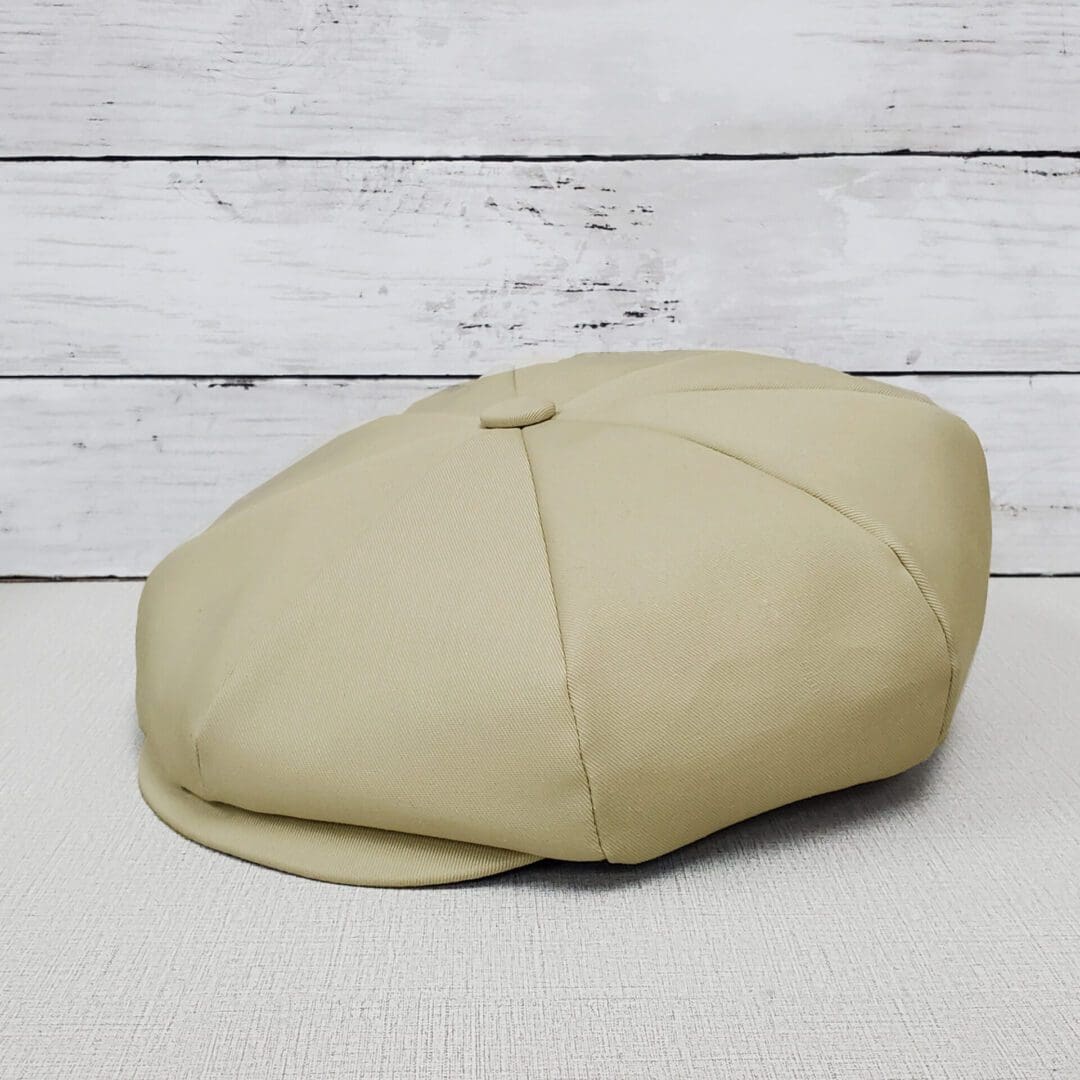 A tan hat sitting on top of a wooden table.