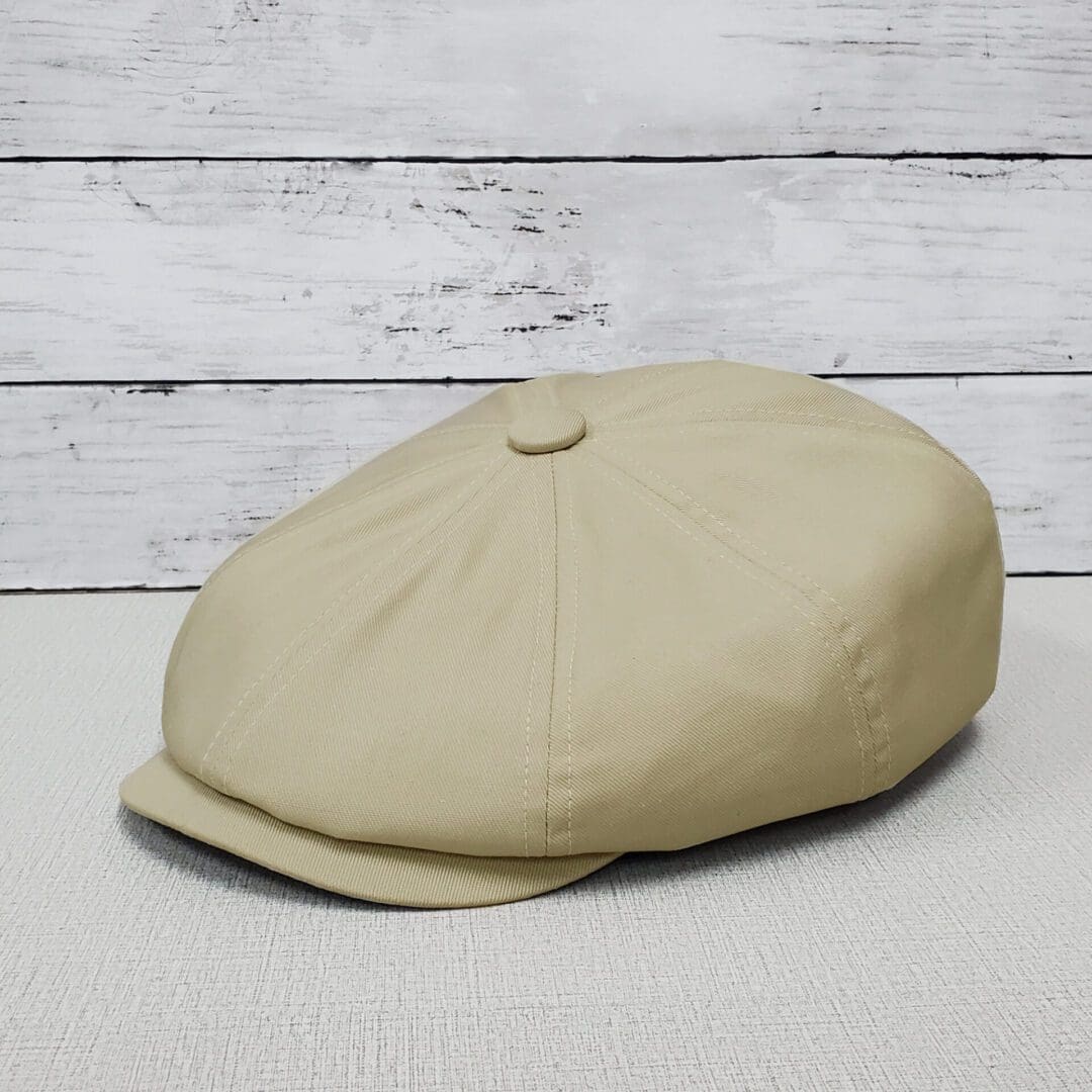 A tan hat sitting on top of a wooden table.