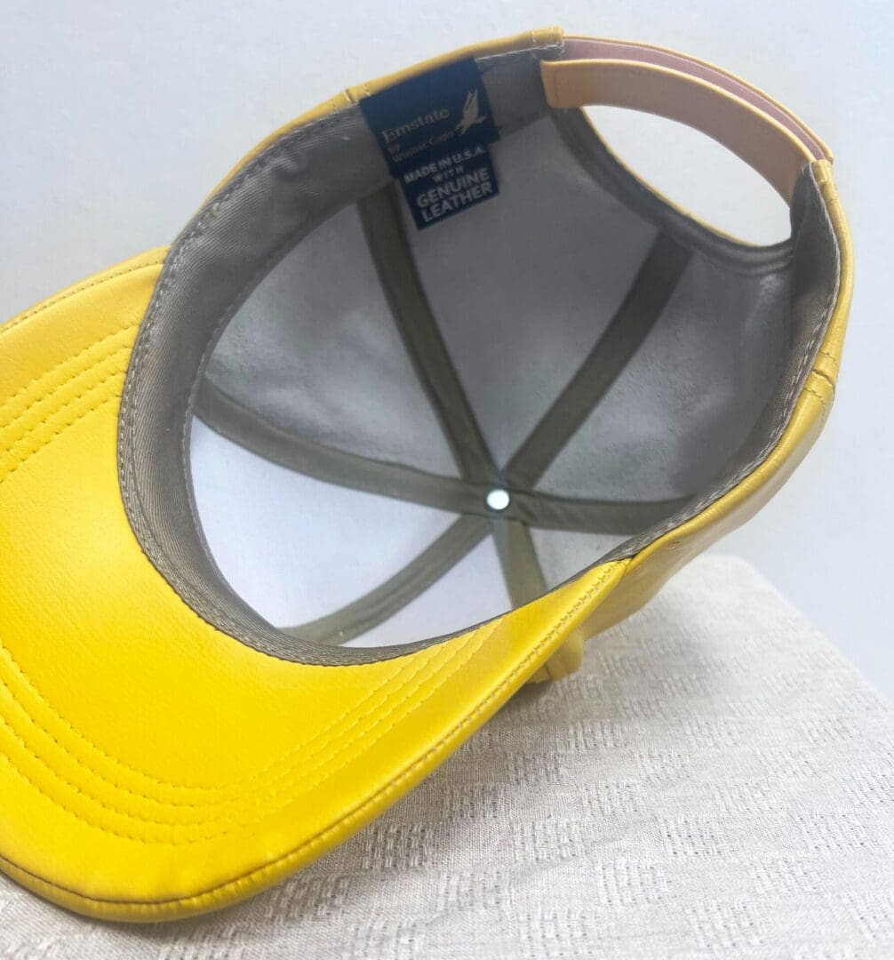 A yellow hat is sitting on top of a white table.