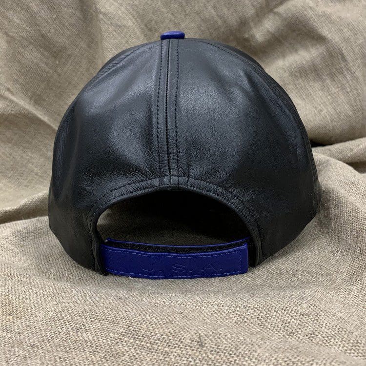 A black leather hat with blue trim on top of a blanket.