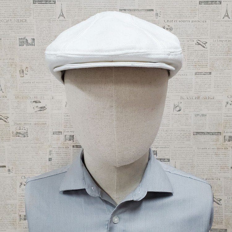 A mannequin wearing a white hat and shirt.