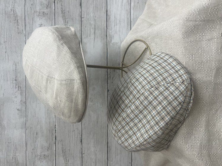 Two hats are sitting on a table next to each other.