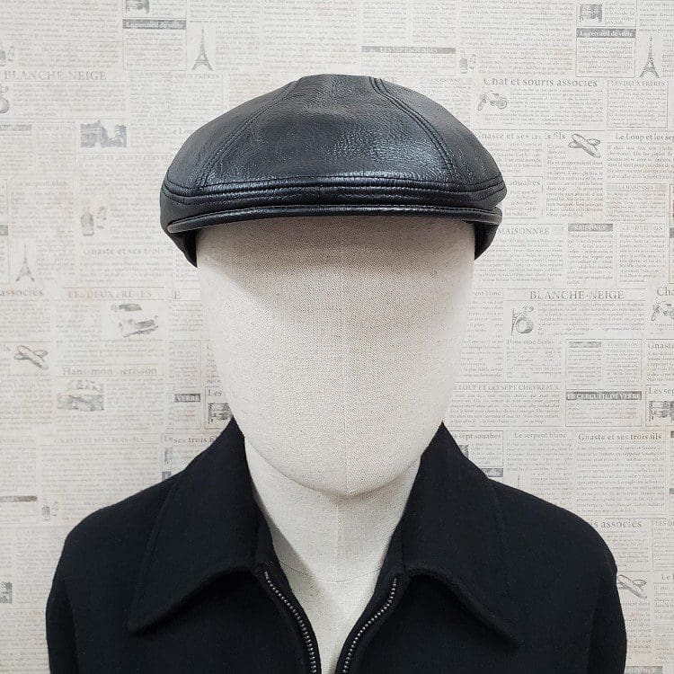 A man wearing a black leather hat and jacket.