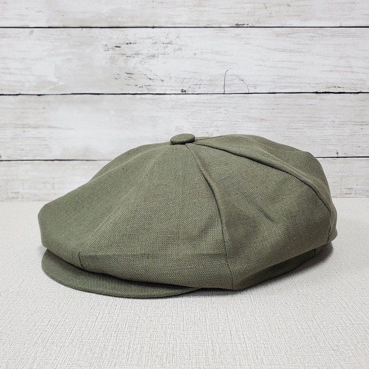 A green hat sitting on top of a wooden table.